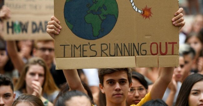 Protester with sign "Time's Running Out"